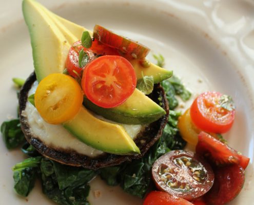 baked mushrooms with eggs, spinach, avocado and tomatoes