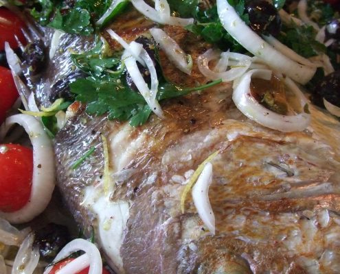 Whole baked fish with tomato and olives