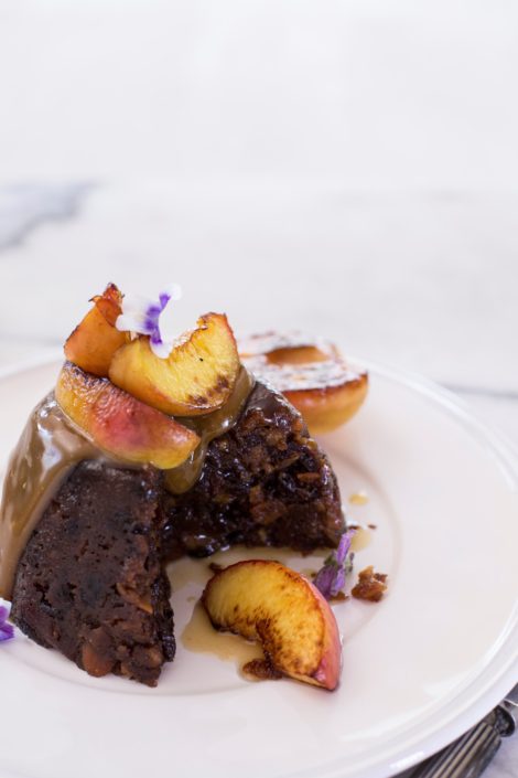 Plum pudding with caramel sauce with grilled peaches